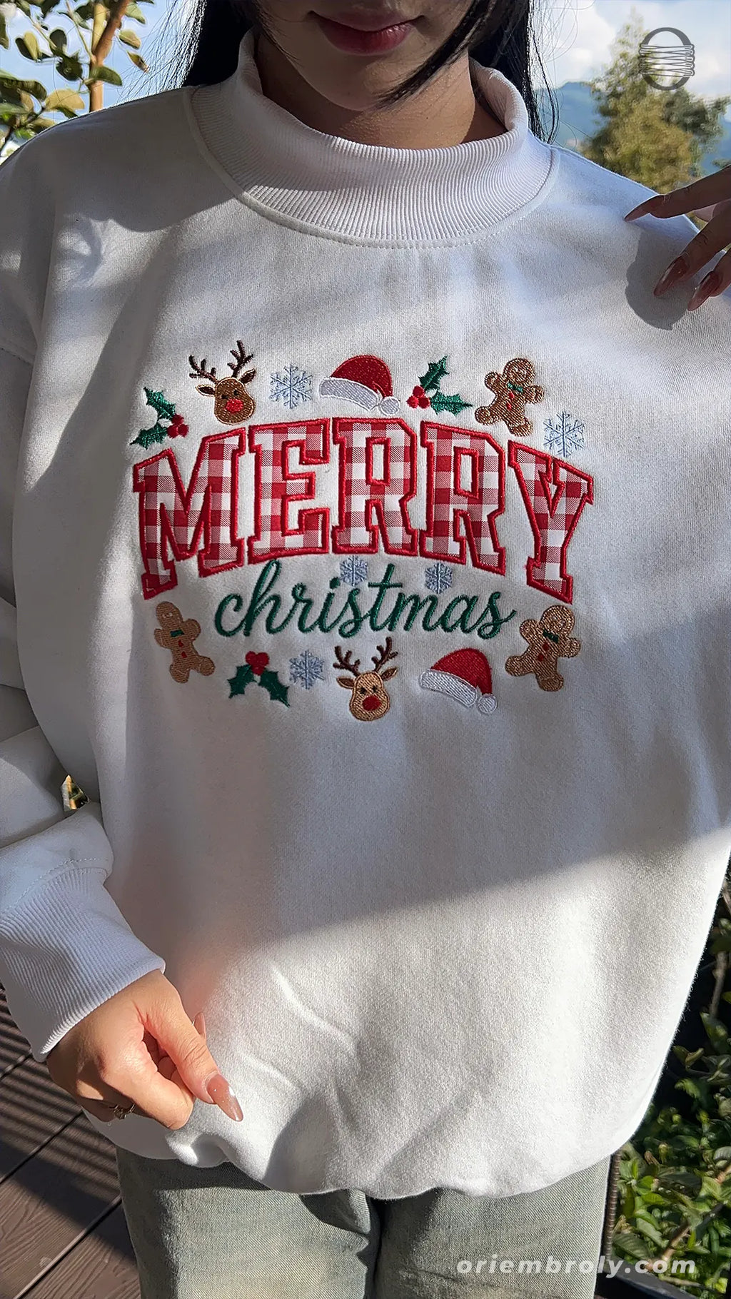 Model wearing an oversized white Merry Christmas plaid embroidered sweater in natural outdoor lighting