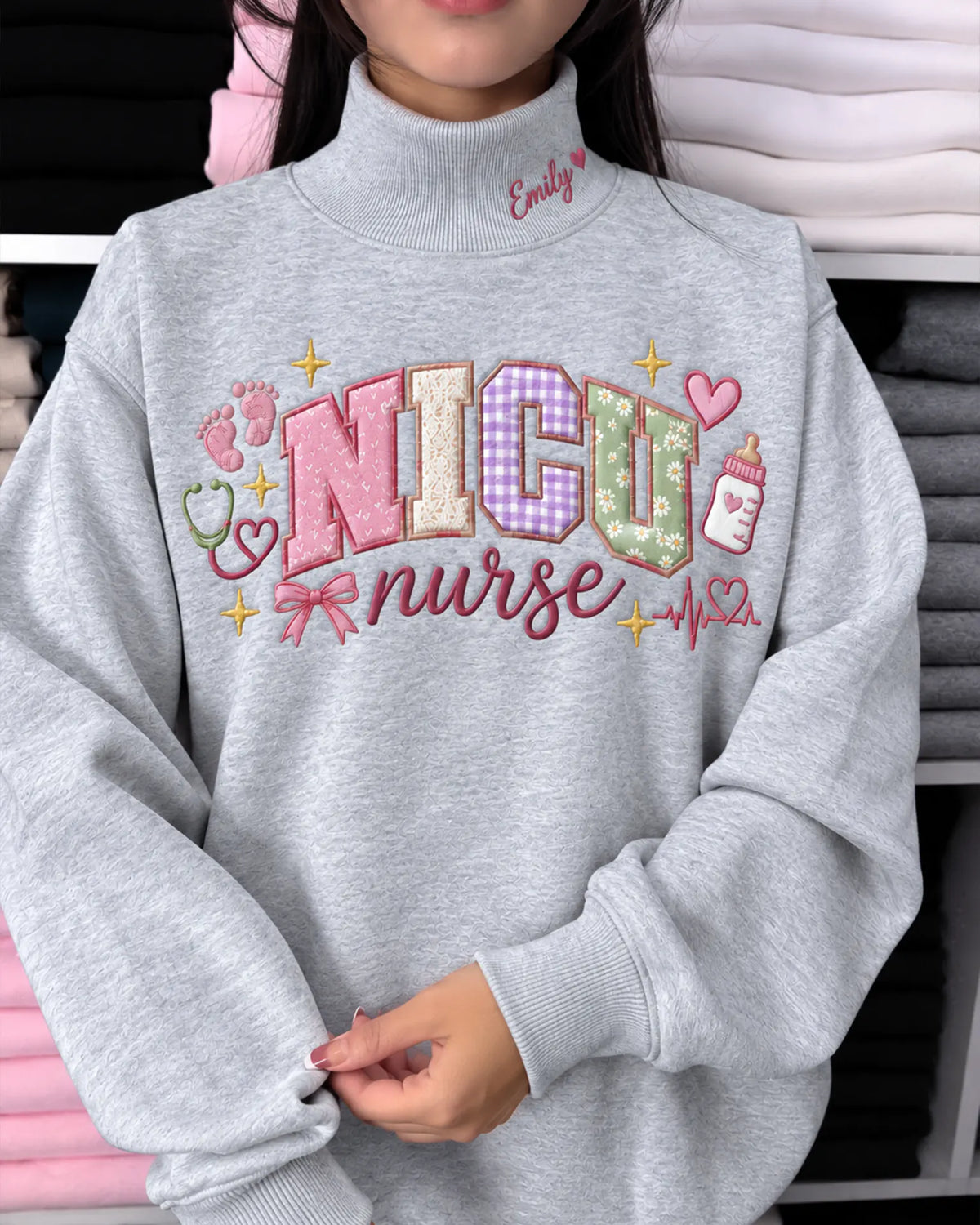 Model wearing an oversized sport grey NICU nurse embroidered crewneck sweatshirt showing detailed pastel letters and ribbon bow