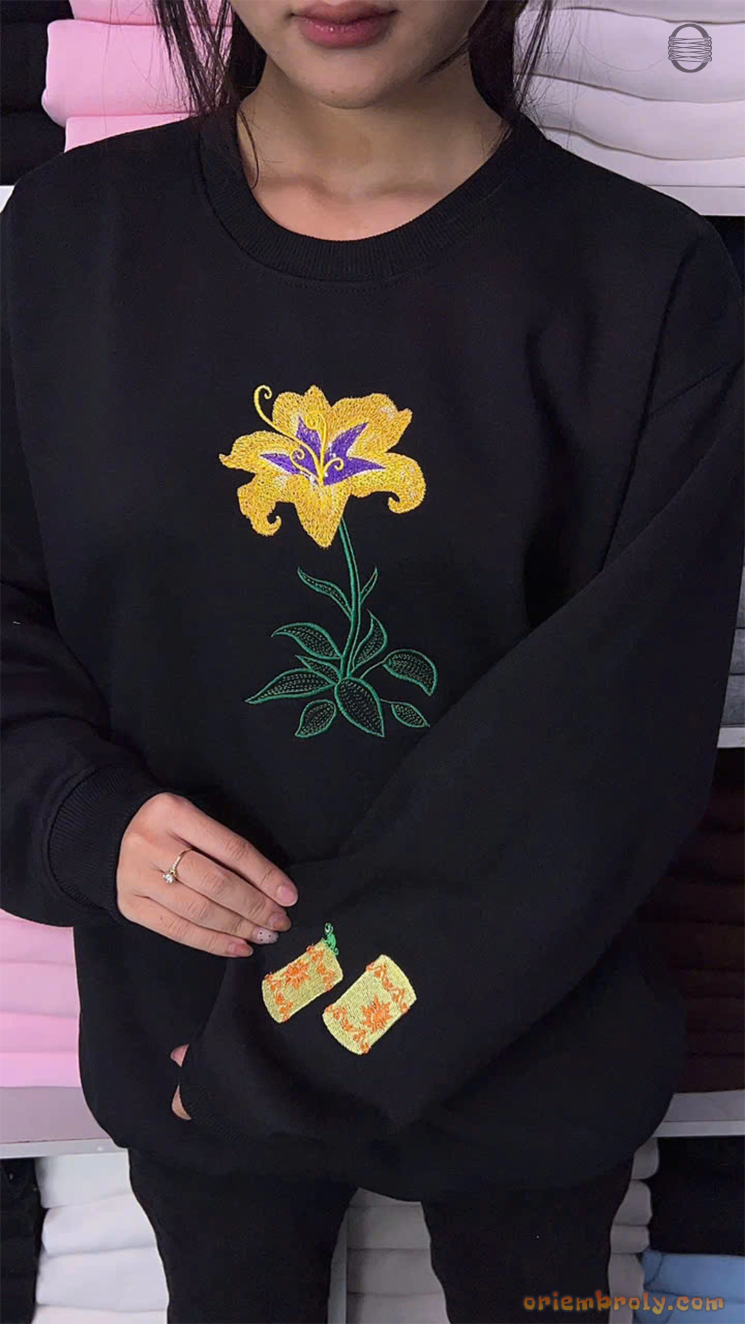 Model wearing an oversized black Tangled Sundrop flower embroidered sweatshirt with floating lantern sleeve embroidery