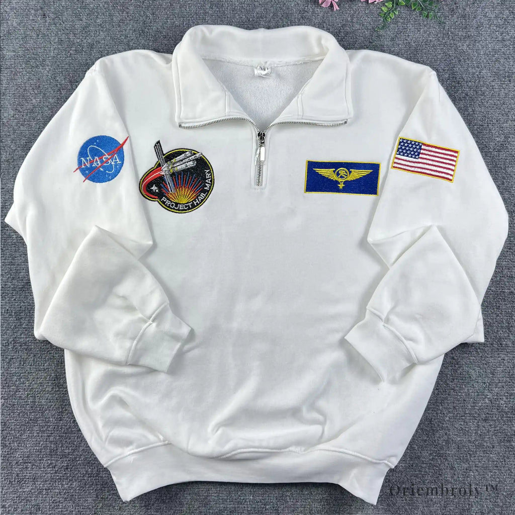 Oversized white quarter-zip with multi-patch NASA embroidery. Modern streetwear piece inspired by vintage 90s space agency merchandise and technical flight gear.