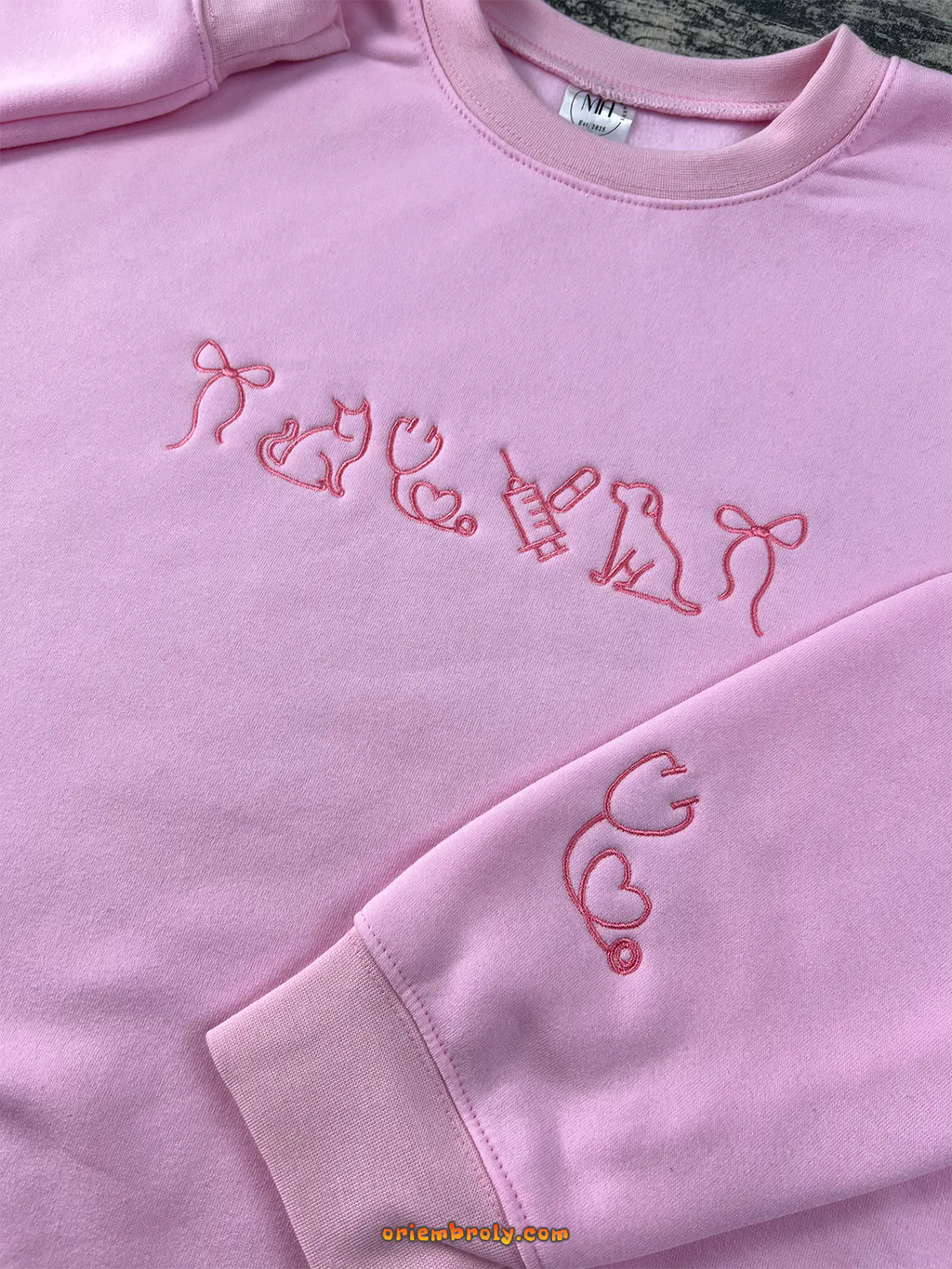 Light pink embroidered sweatshirt with cat, dog, and stethoscope designs — a cozy gift for veterinary lovers.