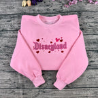 Soft pastel pink sweatshirt with glitter embroidery, perfect for theme park fans and anyone who loves a little magic.