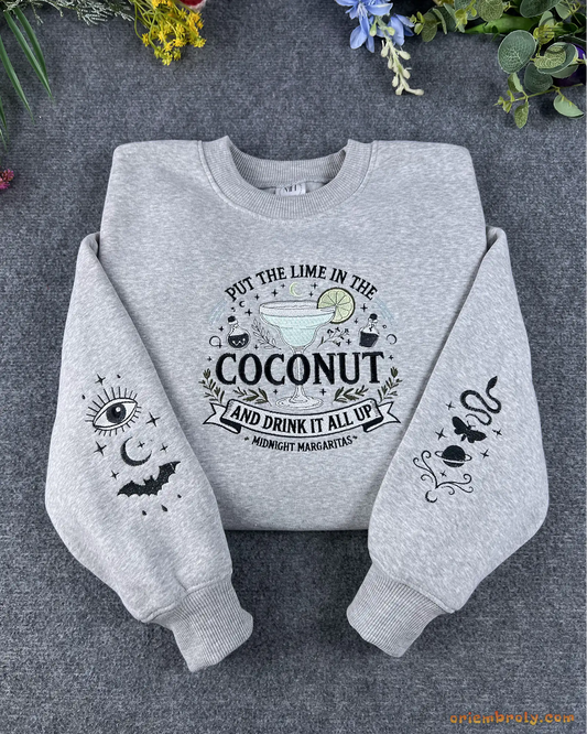 Flat lay of a grey Practical Magic embroidered sweatshirt with Put The Lime In The Coconut text and spooky sleeve embroidery