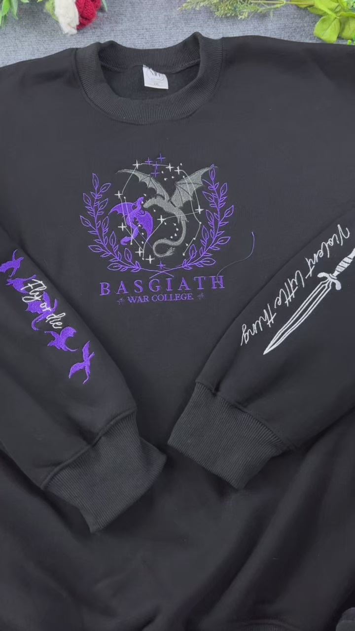 Video showing embroidered details of Basgiath War College dragons logo, dagger, and flying dragons sleeves on a black sweater