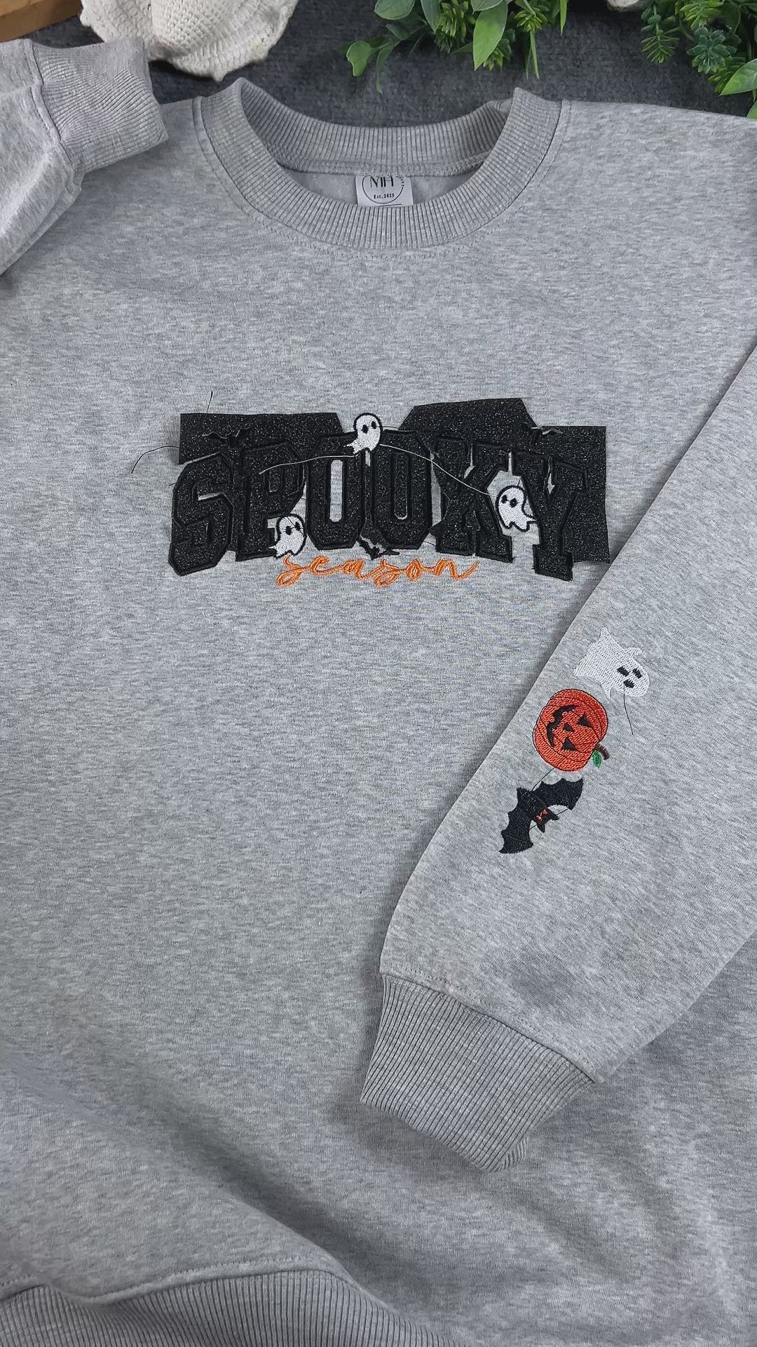 Close-up of embroidered ghost and Spooky Season lettering