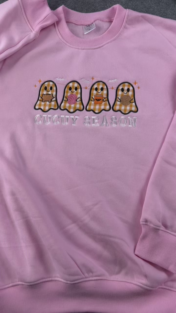 Video showing hand trimming threads and embroidery finishing process for a cute pink Spooky Season plaid ghosts sweatshirt