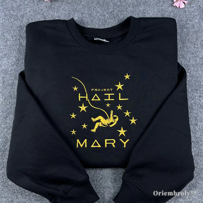 Best-selling black crewneck sweatshirt featuring a detailed yellow embroidered astronaut and "Project Hail Mary" book title. High-quality science fiction apparel for modern book lovers