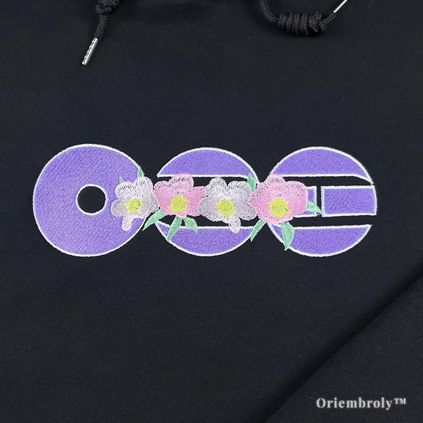 purple circular symbol embroidery on black hoodie