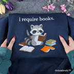 raccoon embroidered sweatshirt reading book design