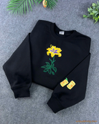 Black Rapunzel crewneck sweatshirt embroidered with a magical yellow lily flower and custom sleeve lantern details
