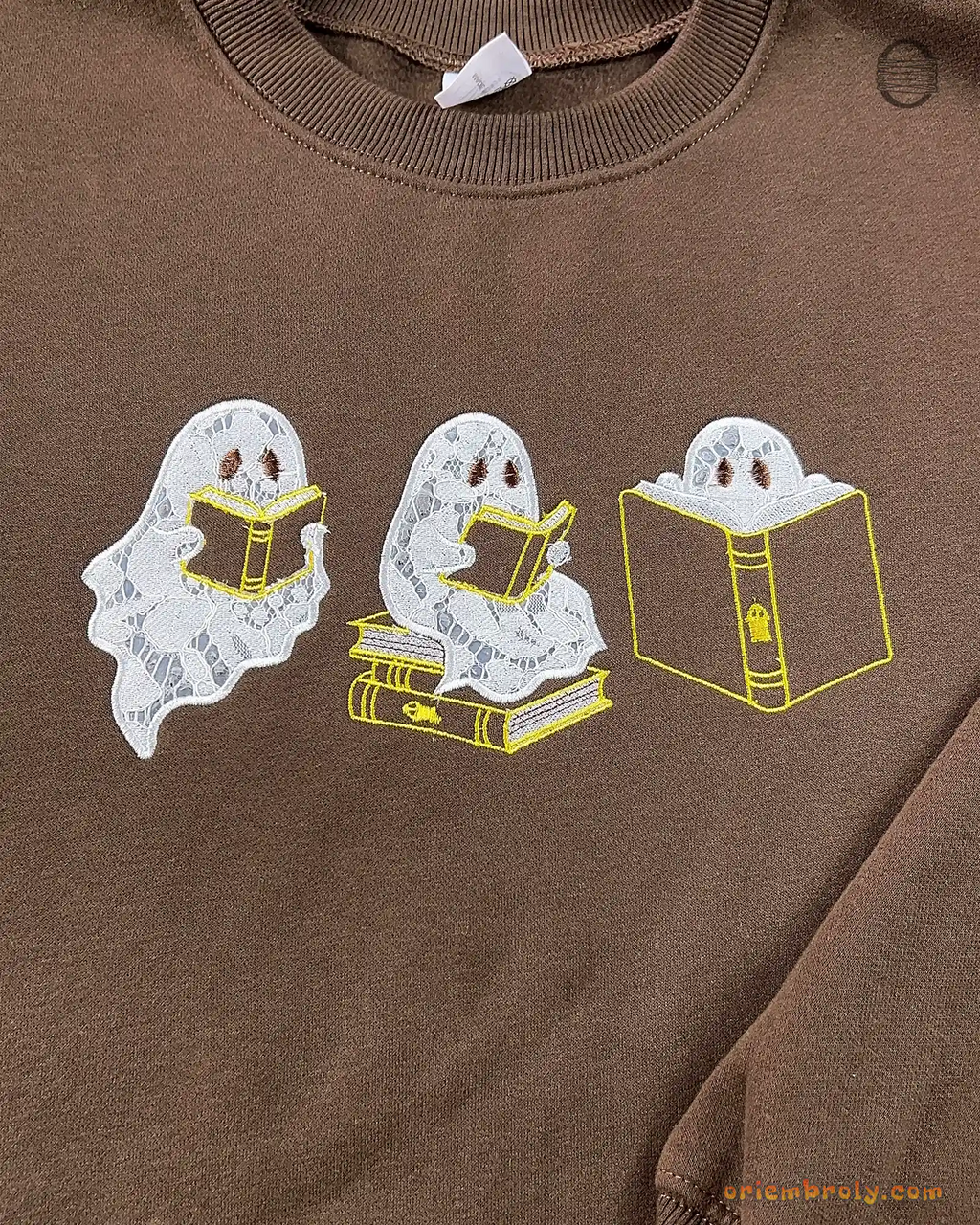 Overview of three cute ghosts reading books embroidered on a chocolate brown sweatshirt