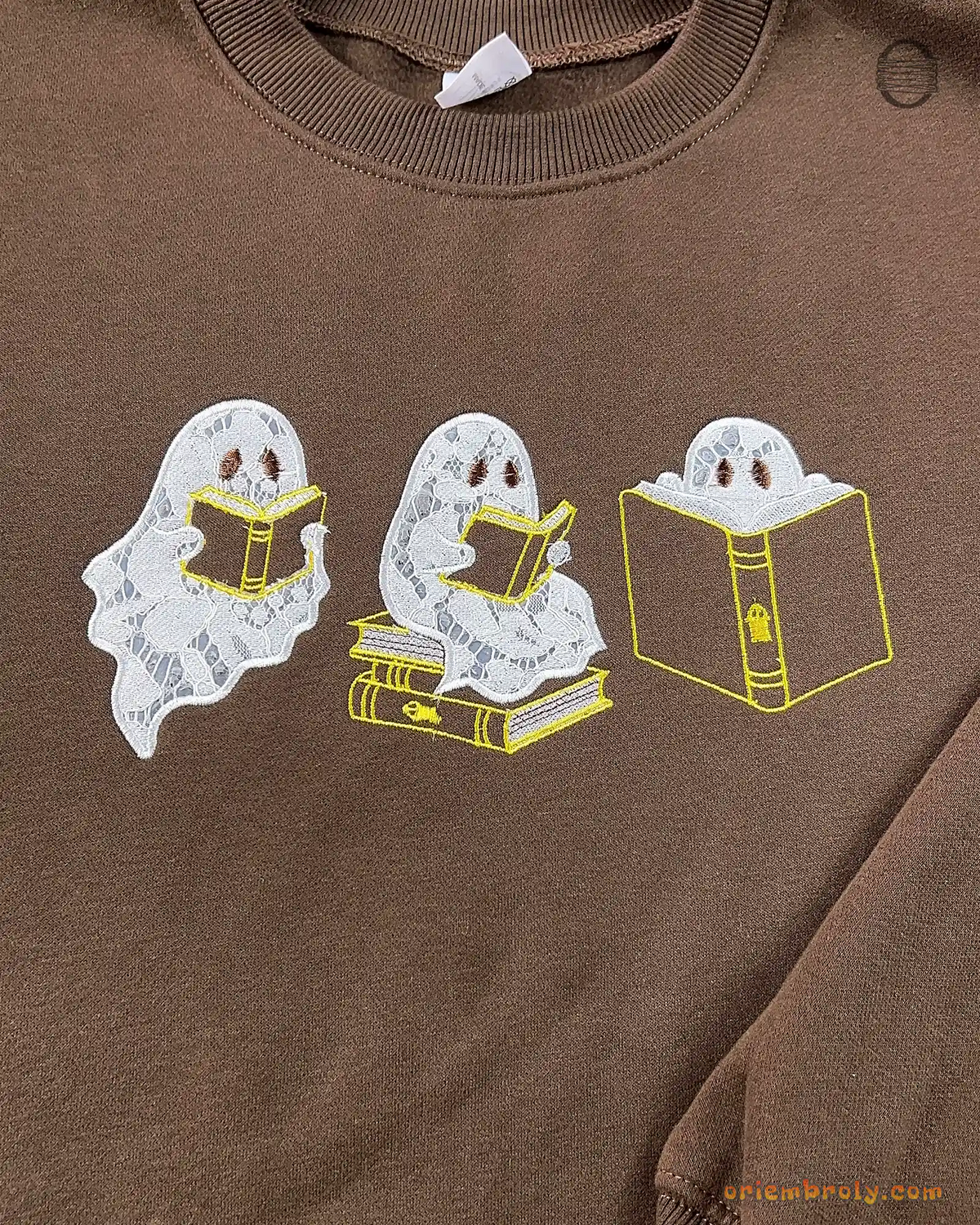 Overview of three cute ghosts reading books embroidered on a chocolate brown sweatshirt