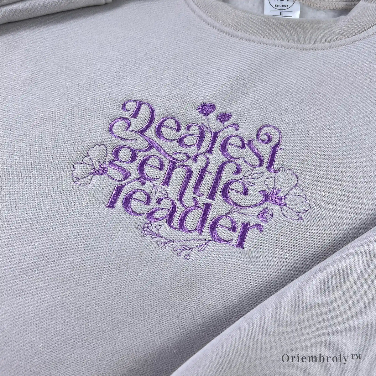 book lover wearing embroidered literary sweatshirt at home