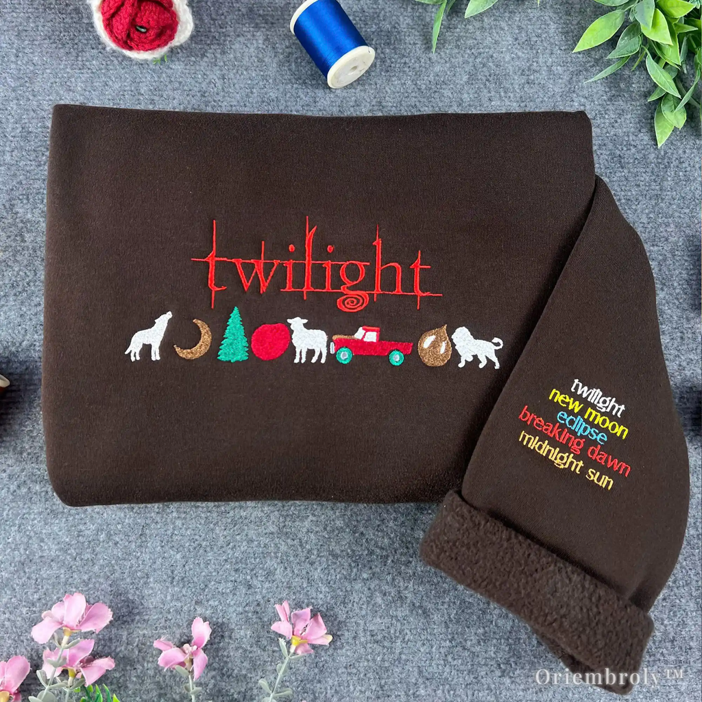 Brown blanket with embroidered 'twilight' series design on a textured surface with flowers and thread.