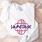 Folded white sweatshirt with 'HUNTRX' logo on a wooden surface