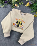 Sand beige Hocus Pocus embroidered crewneck sweatshirt surrounded by colorful flowers and autumn decor