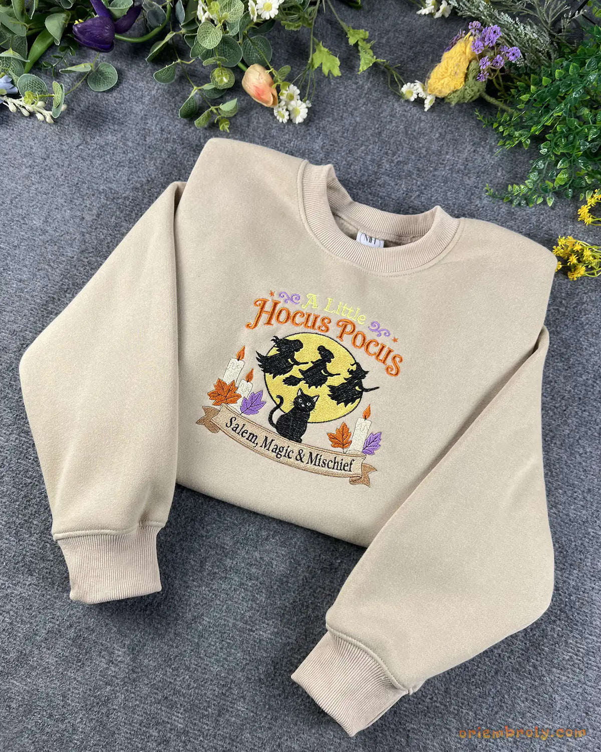 Sand beige Hocus Pocus embroidered crewneck sweatshirt surrounded by colorful flowers and autumn decor