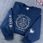 Sarah J. Maas bookish merch: Navy Terrasen sweater with intricate white embroidery for Aelin fans