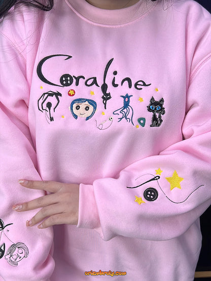 Pink sweatshirt with 'Coraline' design featuring characters and text.