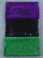 Close-up texture of purple, black, and green sequin sparkle fabric swatches for custom patches