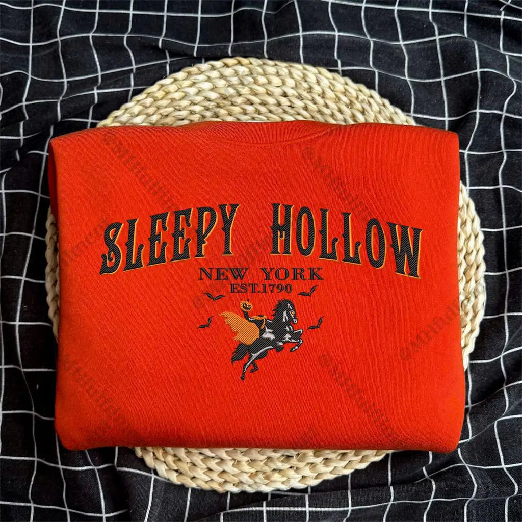 Red blanket with 'Sleepy Hollow New York' text and horse graphic on a woven basket against a black checkered background.
