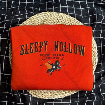 Red blanket with 'Sleepy Hollow New York' text and horse graphic on a woven basket against a black checkered background.