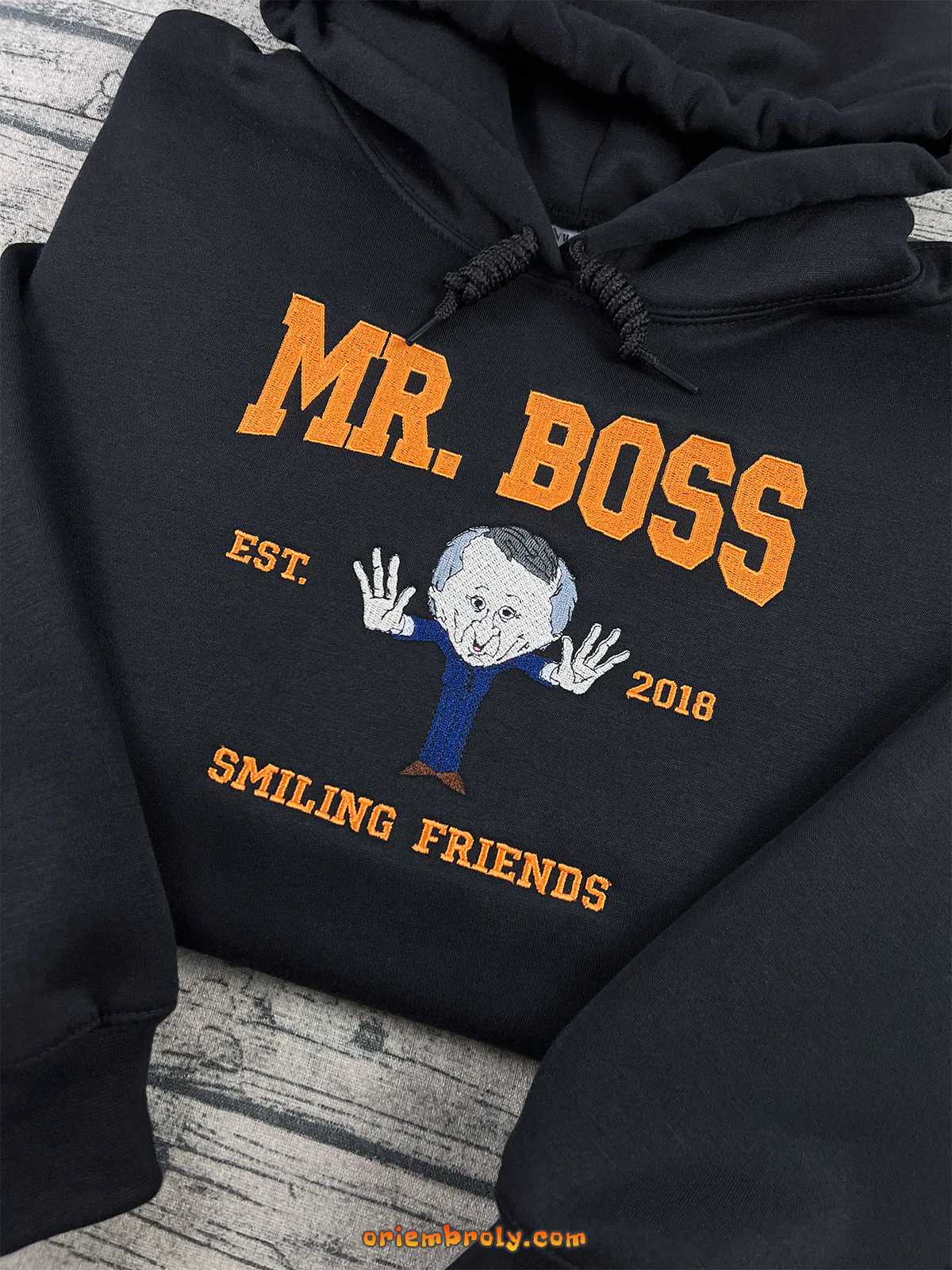 Black hoodie with embroidered winking caricature