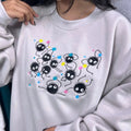 Person wearing a light gray sweatshirt with cartoon character design