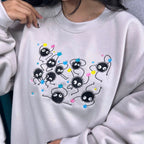 Person wearing a light gray sweatshirt with cartoon character design