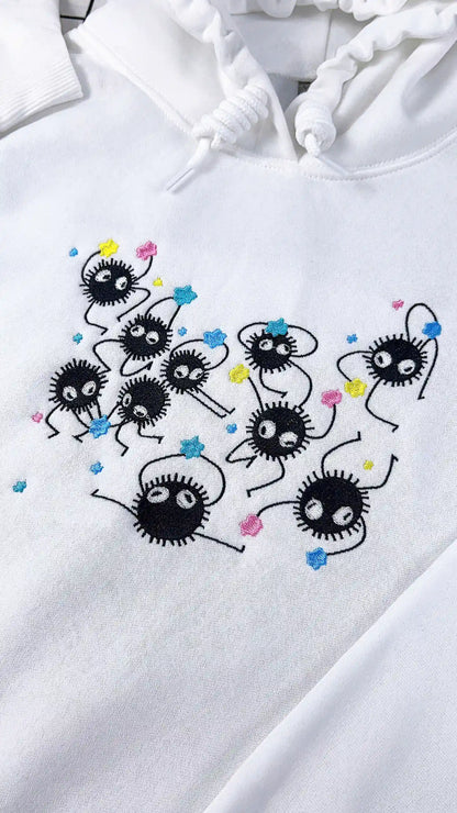White hoodie with black embroidered designs on a white background
