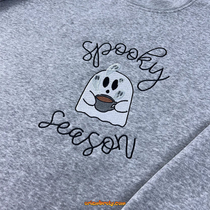 Halloween flatlay of spooky embroidered hoodie with fall decor