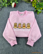 Flat lay of a light pink crewneck sweatshirt embroidered with Spooky Season text and four cute plaid pattern ghosts