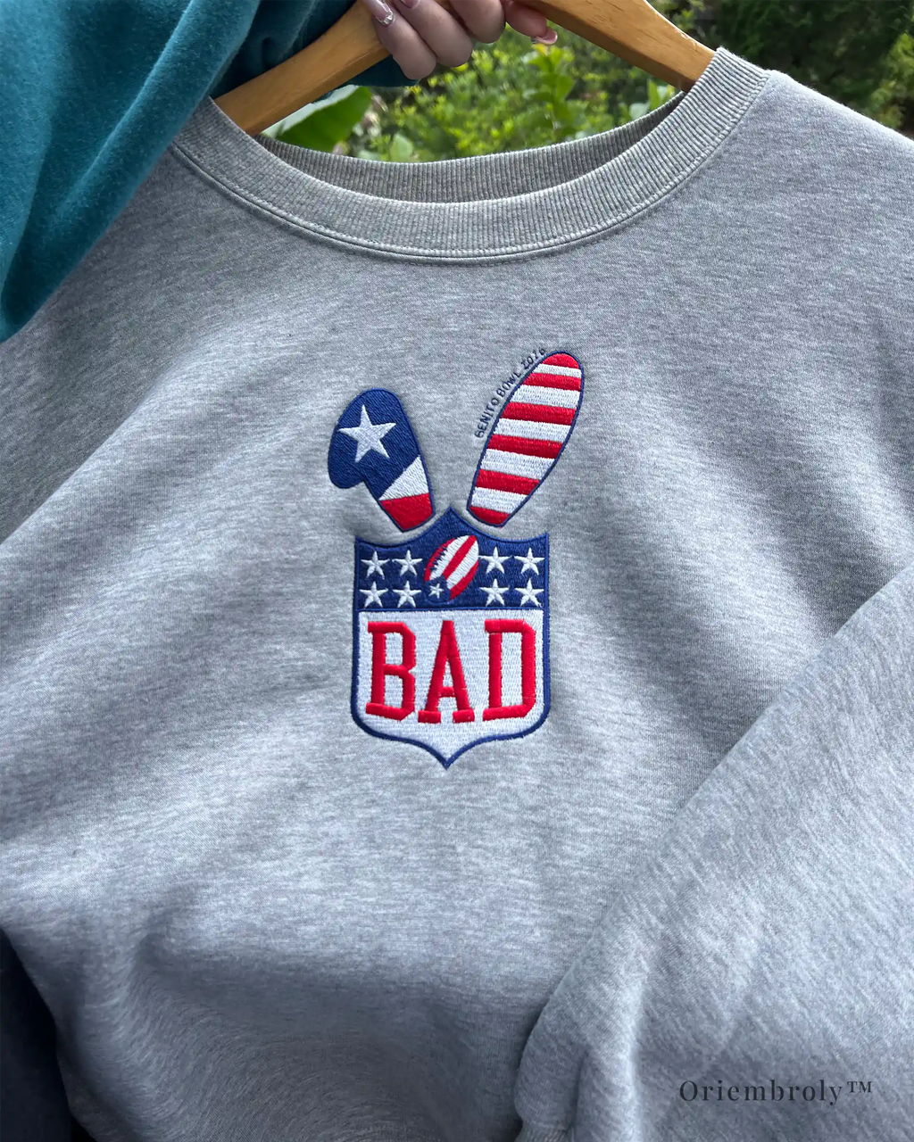 Sports-style embroidered crest on grey crewneck sweatshirt