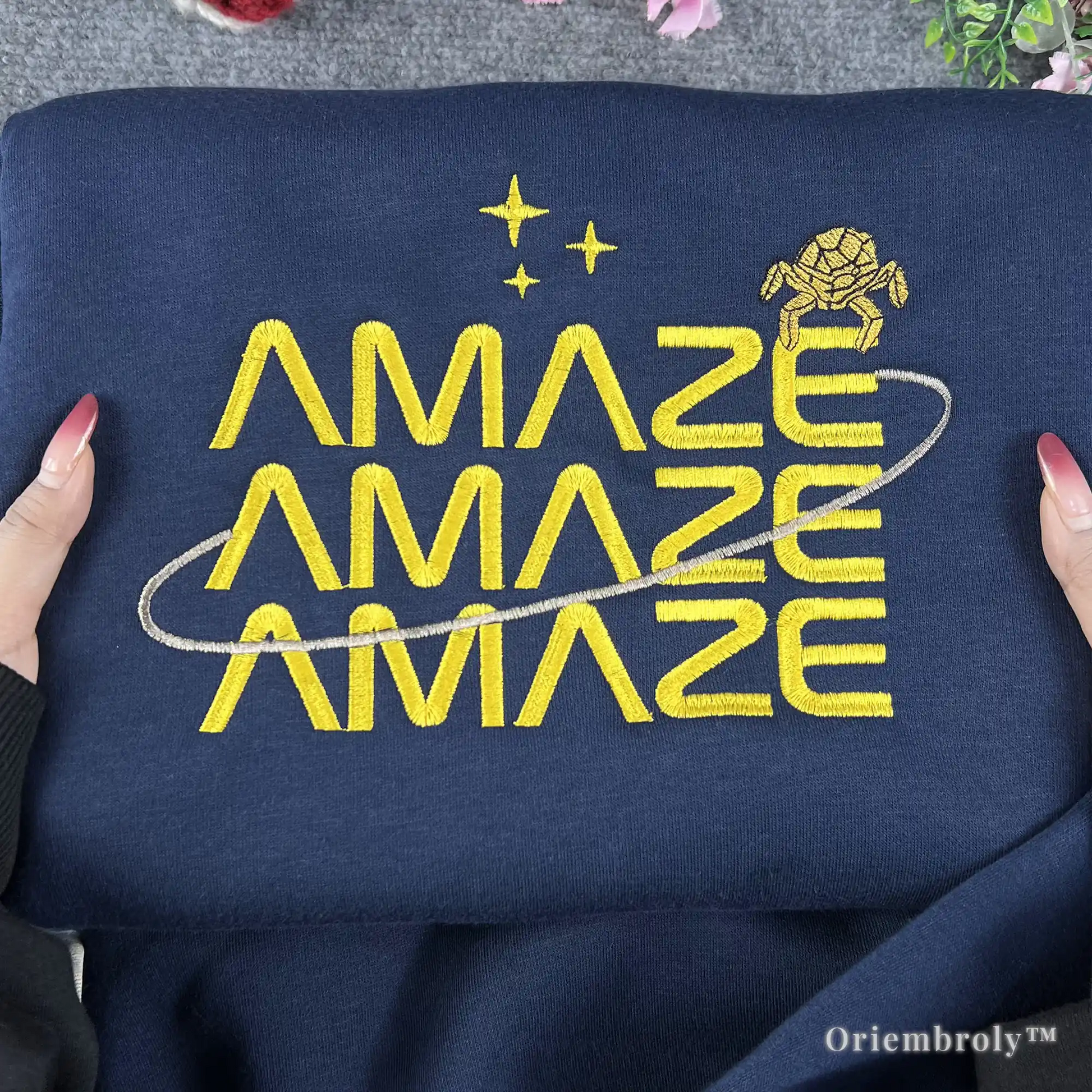 STEM-core aesthetic navy crewneck with minimalist sci-fi embroidery. Futuristic yellow "Amaze Amaze Amaze" design for science teachers, physics students, and space exploration fans