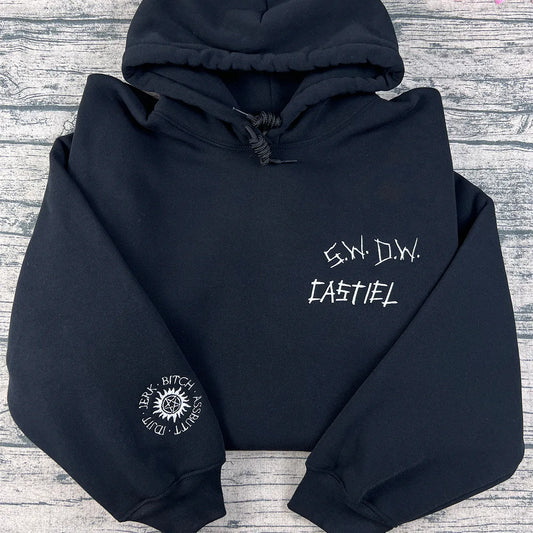 Black hoodie with white text and logo on a gray wooden surface