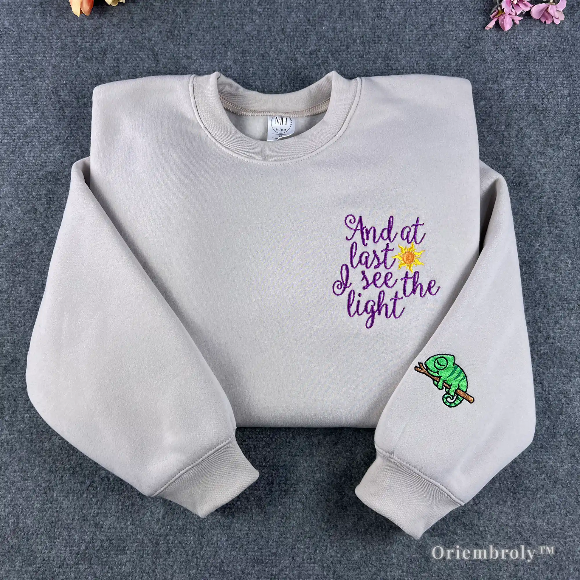Cream Tangled "And at last I see the light" embroidered sweatshirt with Pascal on sleeve.