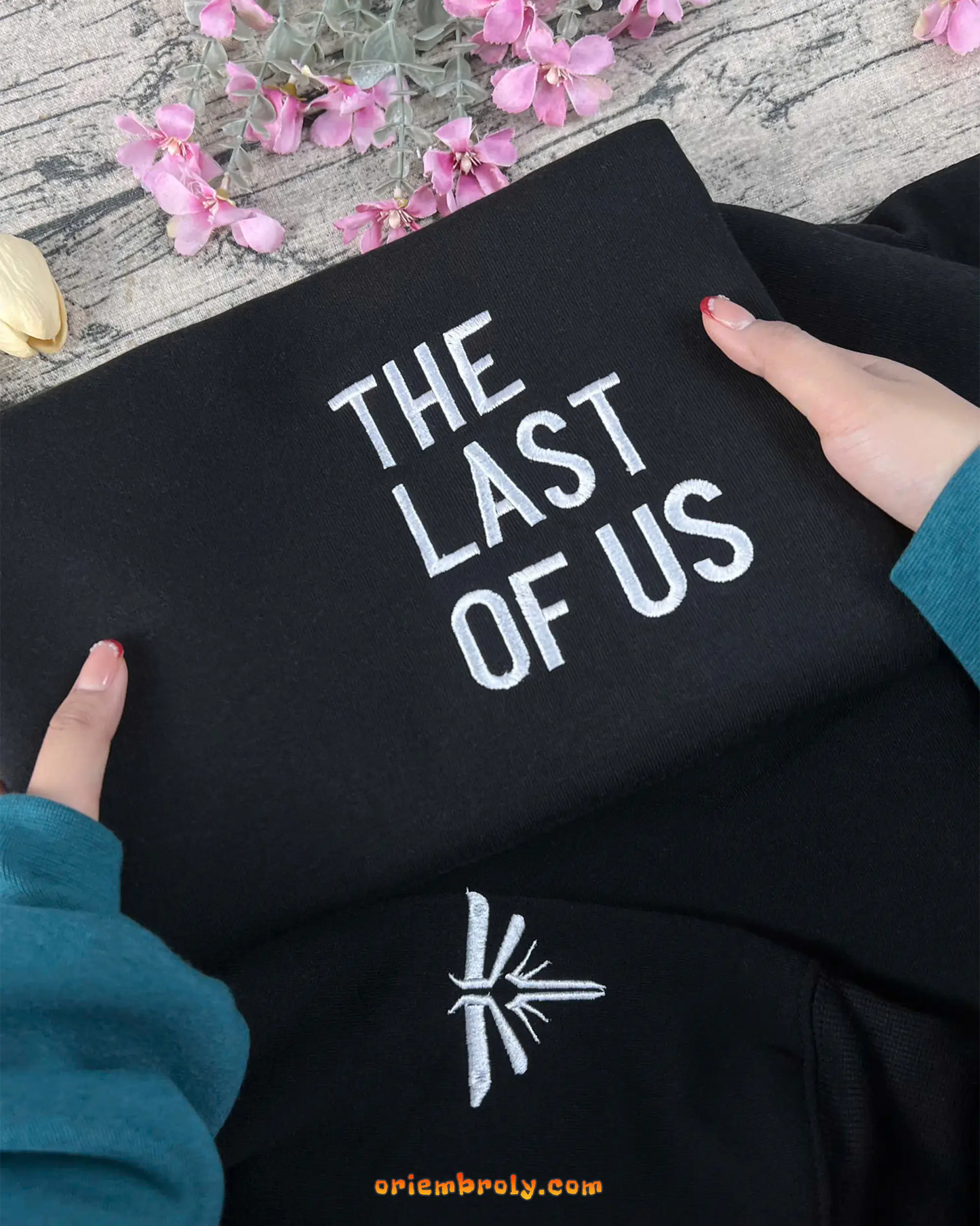 White moth embroidery detail on sleeve cuff