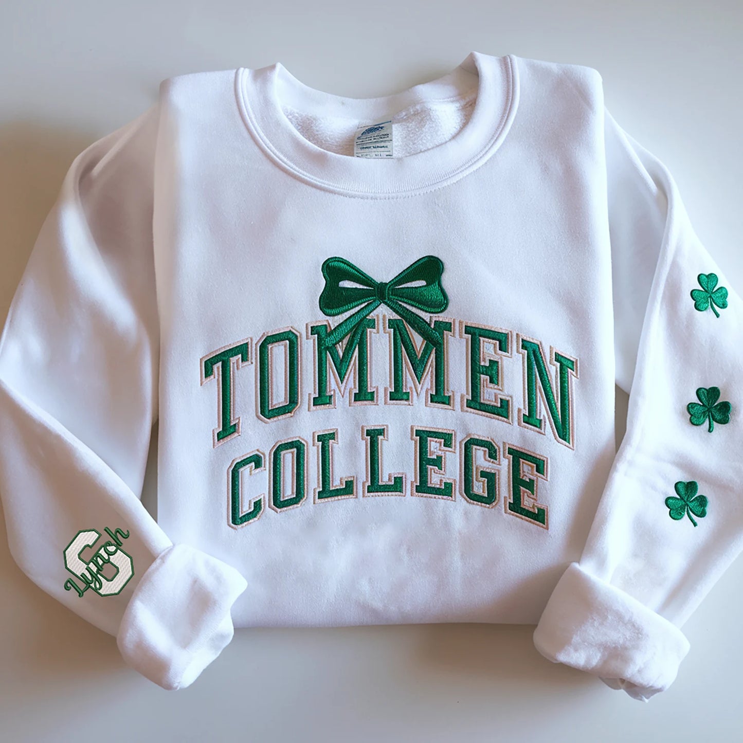 St. Patrick’s Day embroidered sweatshirt featuring Tommen College lettering, bow, and shamrocks for a festive and stylish look.