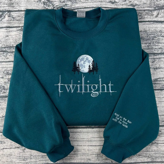 Teal sweatshirt with 'Twilight' design on a wooden surface
