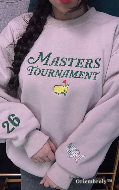 Detailed embroidery of the Masters Tournament on an off-white crewneck. A unique and high-quality gift idea for golfers, featuring a vintage-inspired design and premium satin stitching