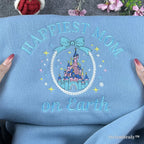A high-quality embroidered Disney Mom hoodie in pastel blue. Featuring a fairytale castle and "Happiest Mom on Earth" script, it makes a thoughtful and unique gift for Disney-loving moms