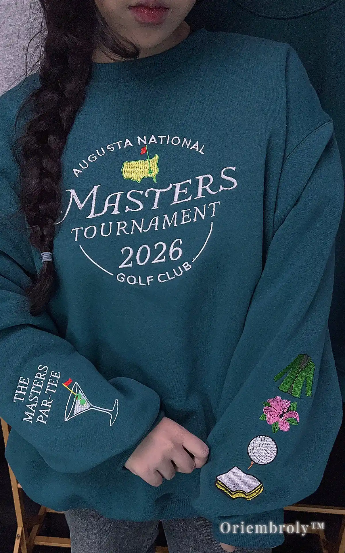 Vintage-style Masters Golf Club 2026 embroidered crewneck in deep teal. Timeless sportswear design featuring classic Augusta National colors and retro golf motifs
