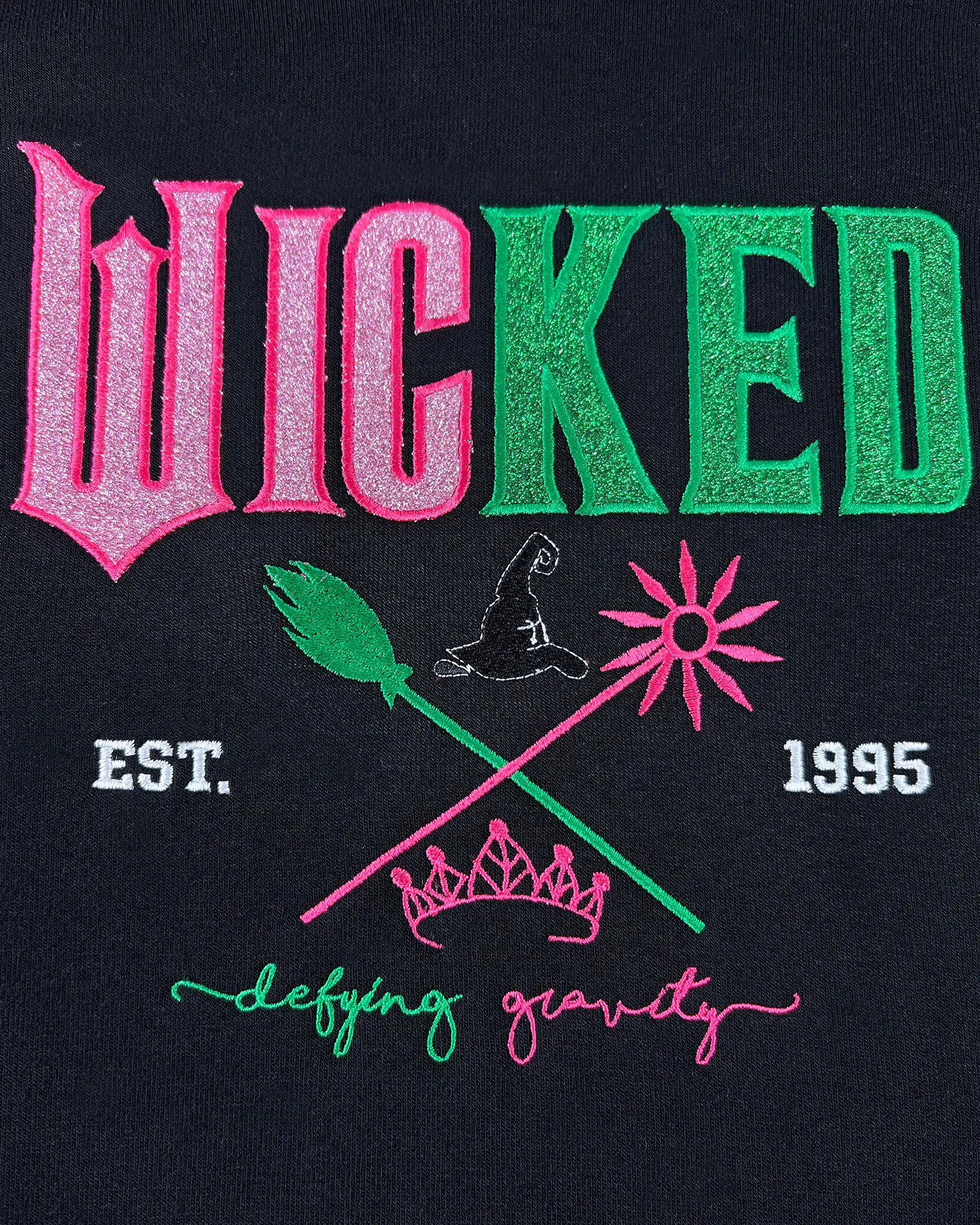Wicked embroidered hoodie with Defy Gravity applique, inspired by Glinda and Elphaba. Cozy Halloween sweatshirt and witch gift idea for women.
