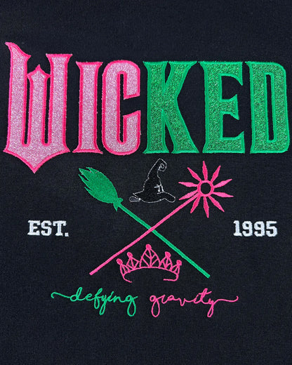 Wicked embroidered hoodie with Defy Gravity applique, inspired by Glinda and Elphaba. Cozy Halloween sweatshirt and witch gift idea for women.
