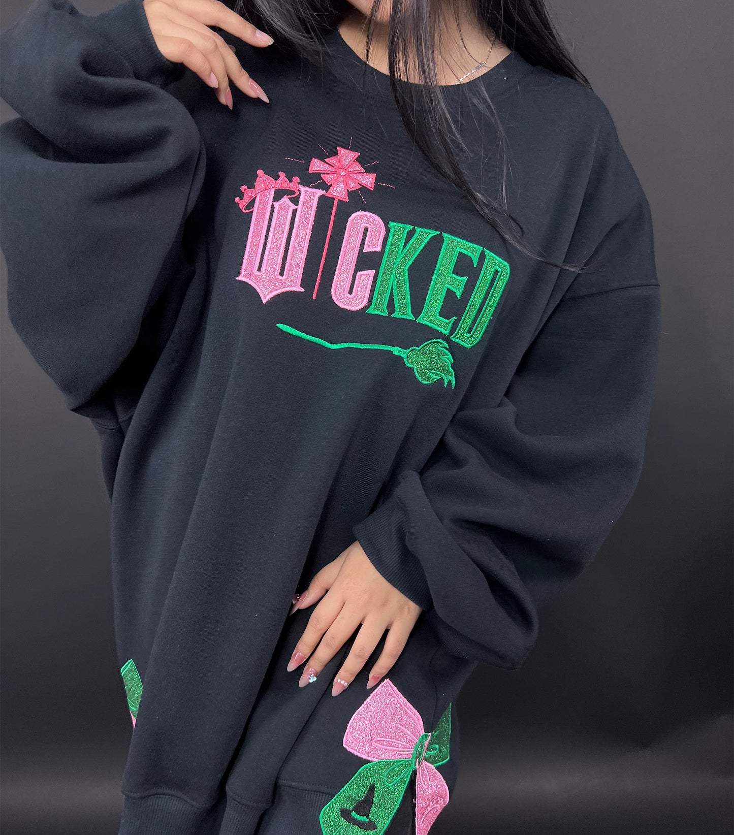 Wicked Movie embroidered sweatshirt featuring Defying Gravity design, side bow embroidery, and inspired by Glinda and Elphaba. Cozy and stylish for Broadway fans.