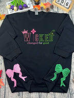 Black sweatshirt with colorful text and bows on a wooden surface