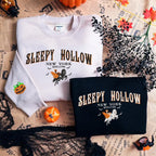 White and black sweatshirts with 'Sleepy Hollow New York' design on a newspaper background.