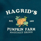 Green sweatshirt with 'Hagrid's Pumpkin Farm' text and pumpkins on a wooden surface