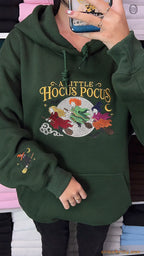 Close-up view of a model styled in a green A Little Hocus Pocus embroidered hoodie showing sleeve details.