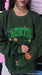 Full length view of model styled in an oversized green Auntie Halloween crewneck sweatshirt with green sequin filled text.